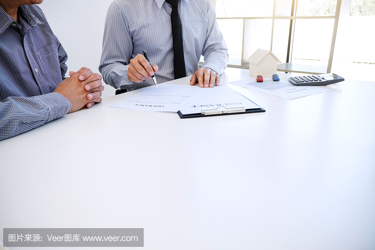 汽车和房屋保险的概念,经纪人向客户提出和咨询决策签订保险表格协议,房屋和房屋模型